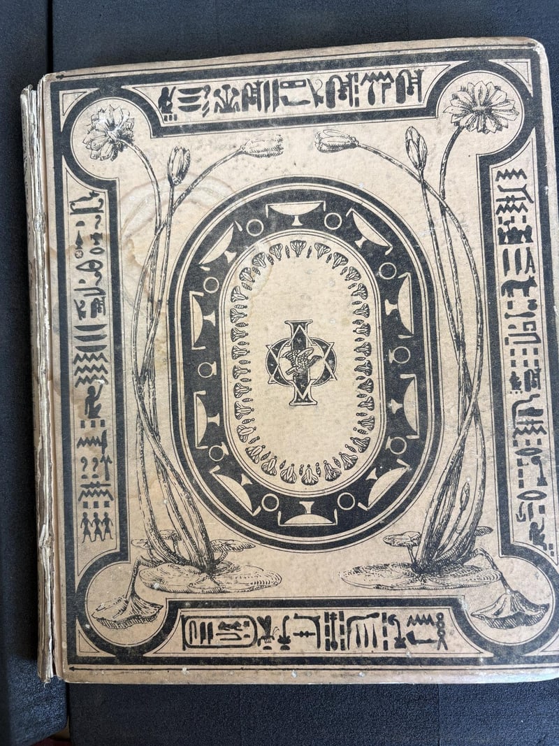 C061: Original cream publisher binding with black Egyptian decoration